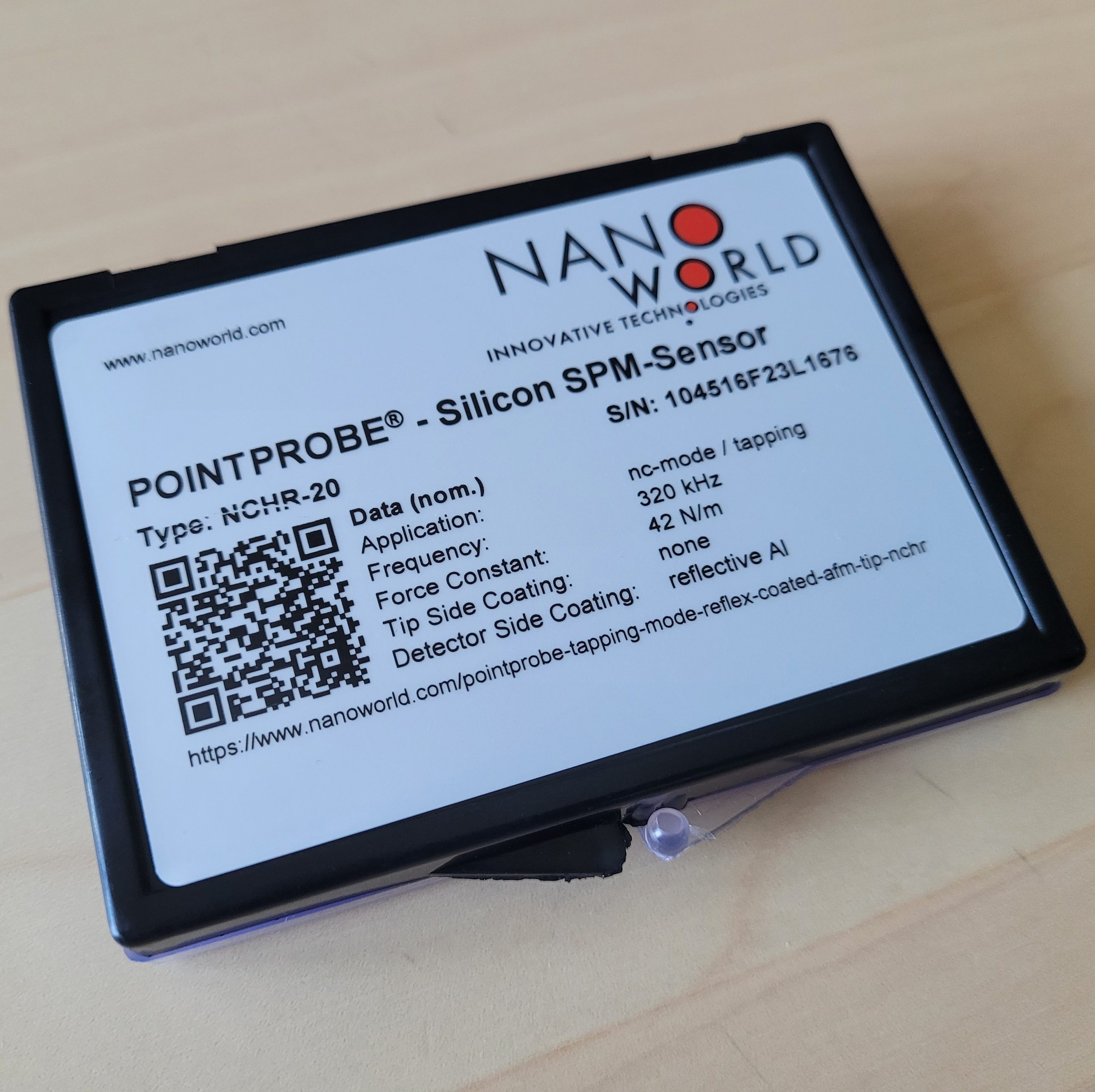 Updated product label on NanoWorld ESD-safe AFM probe packaging featuring a QR code linking to product specifications.